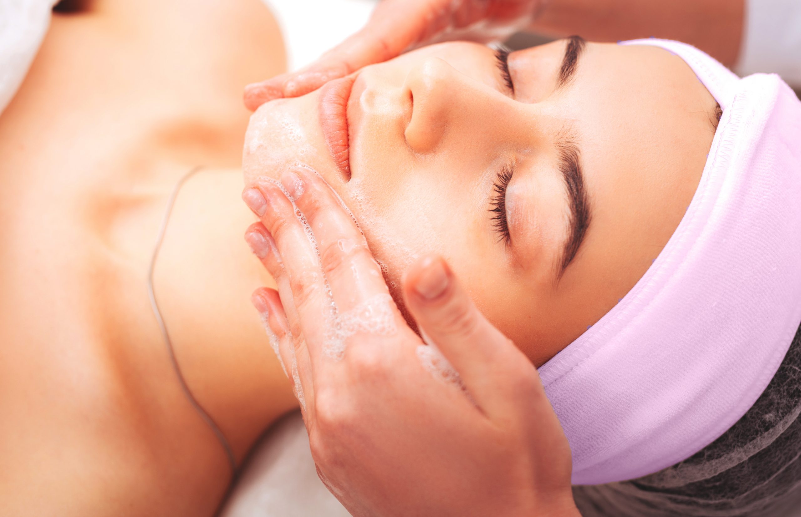 pleasant young woman having a foam face massage